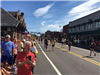 wide angle view of runners at the 6 mile moment in Framingham with historic depot on the left and co