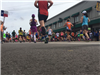 Image of runners backs from an angle on the ground facing buildings on Waverly Street