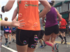 view of the back of a runner in an orange shirt with a child's hand and floating bubbles.