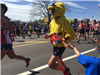 male runner in a chicken costume gives a child a high five