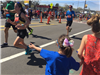 image of a girl with a bow and a blue shirt holding out her hand for runners to high five