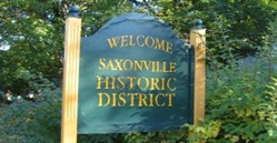 image of the "welcome to historic saxonville sign" - green wooden sign with gold carved letter