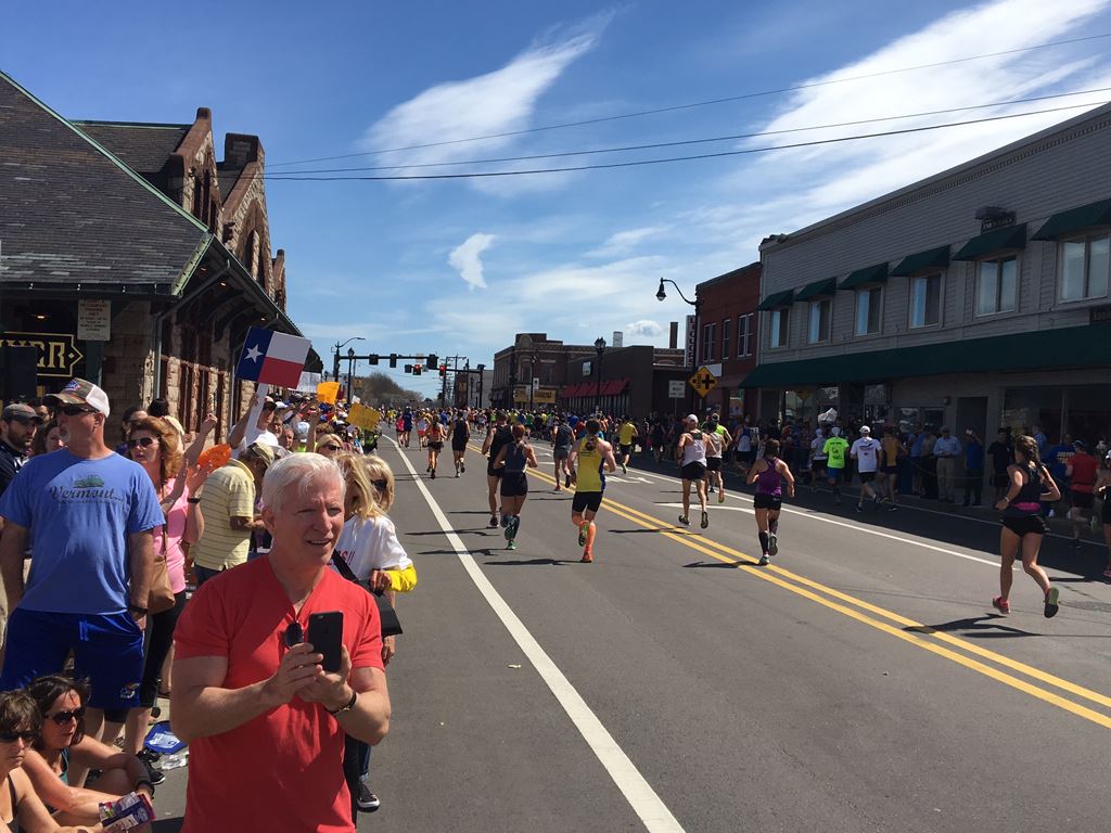wide angle view of runners at the 6 mile moment in Framingham with historic depot on the left and co
