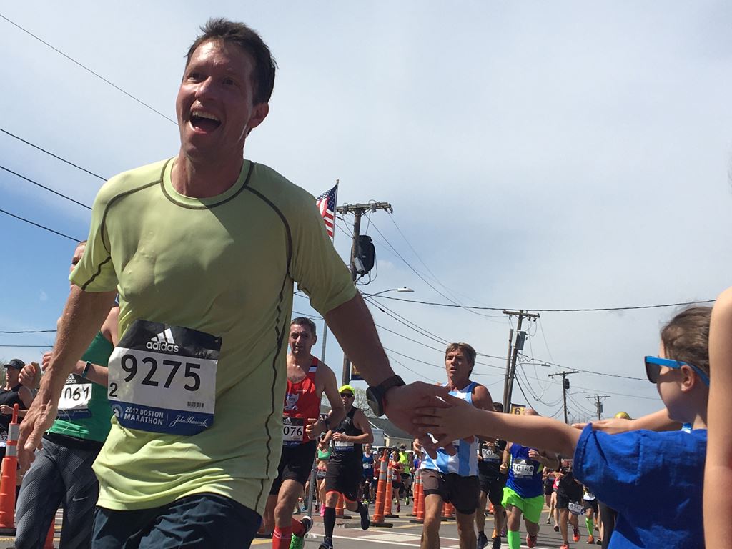 close up view of happy male runner giving a girl with a bow a high five